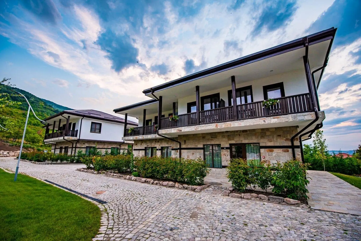 Villa Yustina Hotel exterior with stone facades and wooden balconies