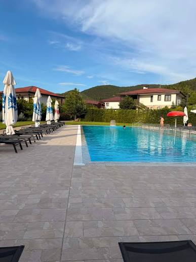 Swimming pool and sun terrace at Villa Yustina with the villas and hills beyond
